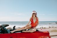 Woman in Red Bikini Top and White Goggles Sitting on Red Convertible Car