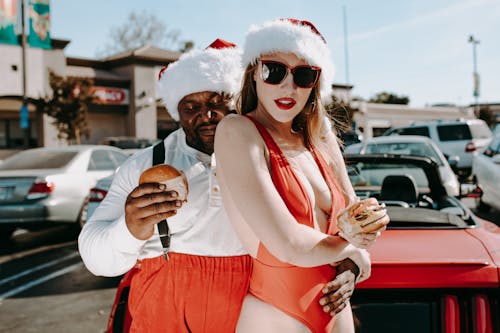 Woman in White Tank Top and Red Shorts Wearing White Sunglasses Holding Ice Cream