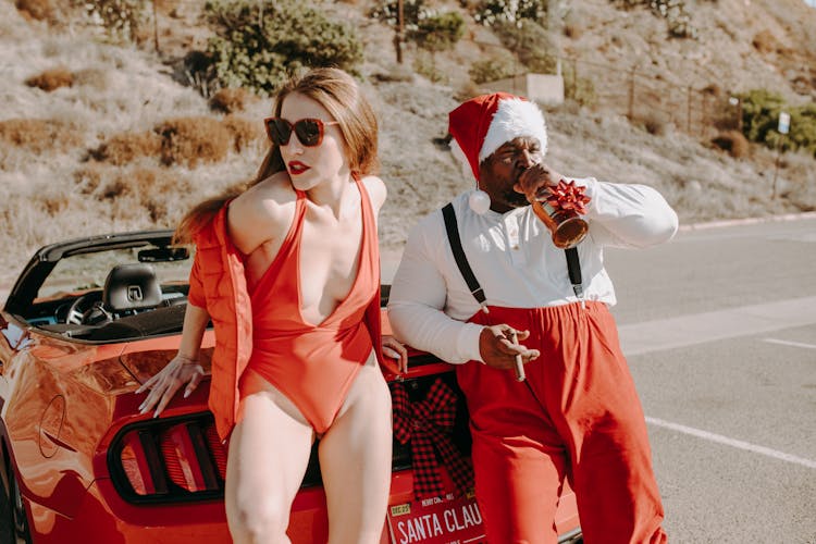 Man In Santa Outfit Drinking And Smoking With A Sexy Woman