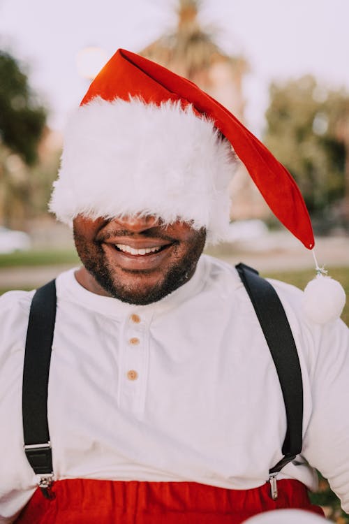 Man Wearing A Santa Hat Covering His Face