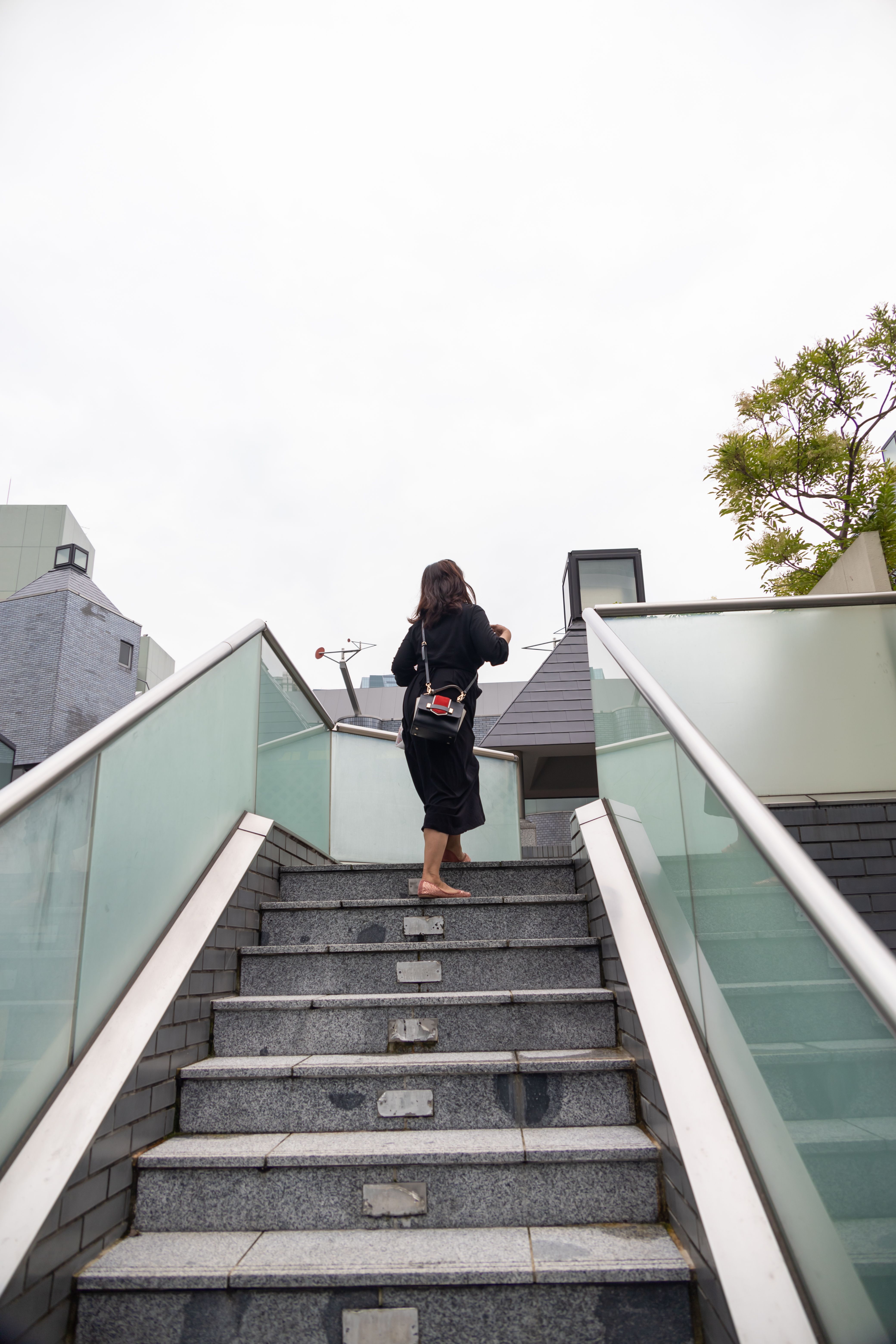 Woman in Black Dress Standing on Gray Concrete Stairs · Free Stock Photo