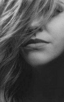 Close-up monochrome portrait of a woman with hair covering part of her face, taken in Kyiv, Ukraine.