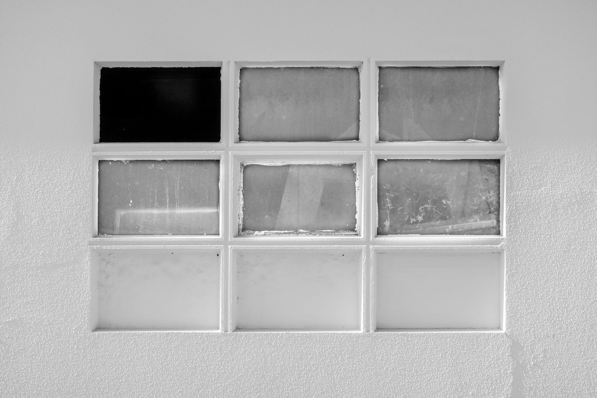 Explore the textures and geometric patterns of a nine-panel minimalist window design.