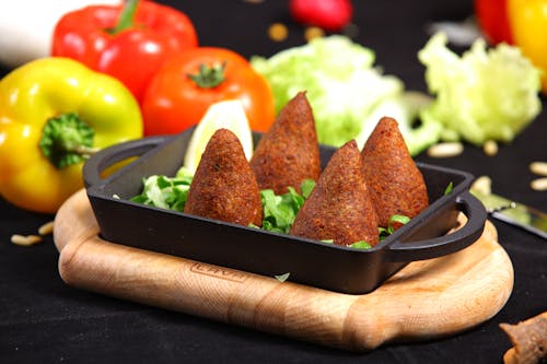 Close Up Photo of Meat Appetizer Kibbeh on Black Cast Iron Tray