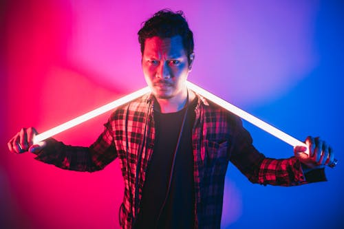 Free Serious ethnic man with lamps near neon wall Stock Photo