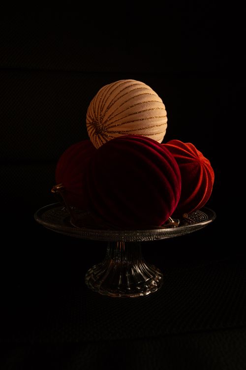 Free Close-up of velvet and gold Christmas baubles on a glass stand against a dark background. Stock Photo