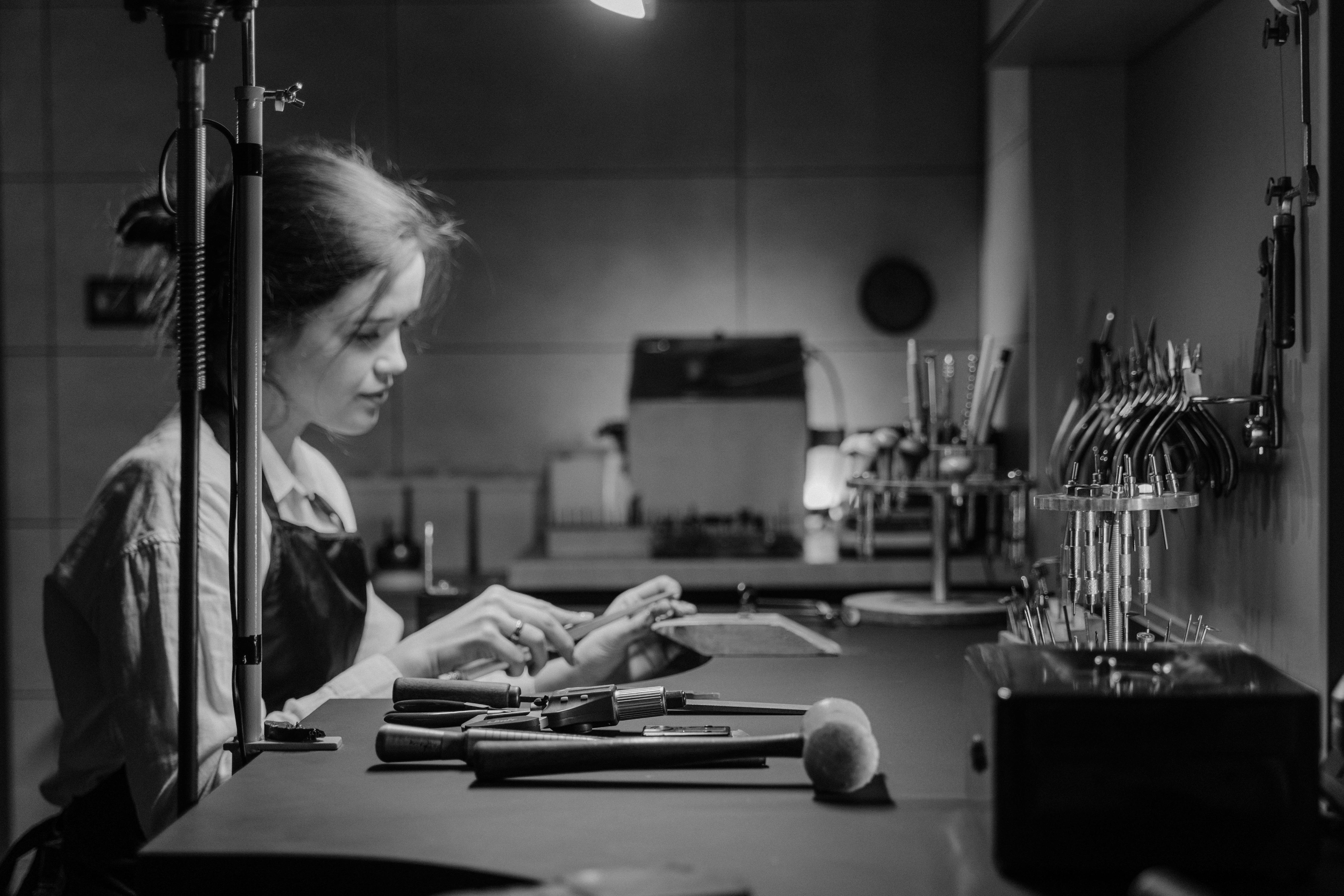 grayscale photo of woman in white shirt holding pen and paper