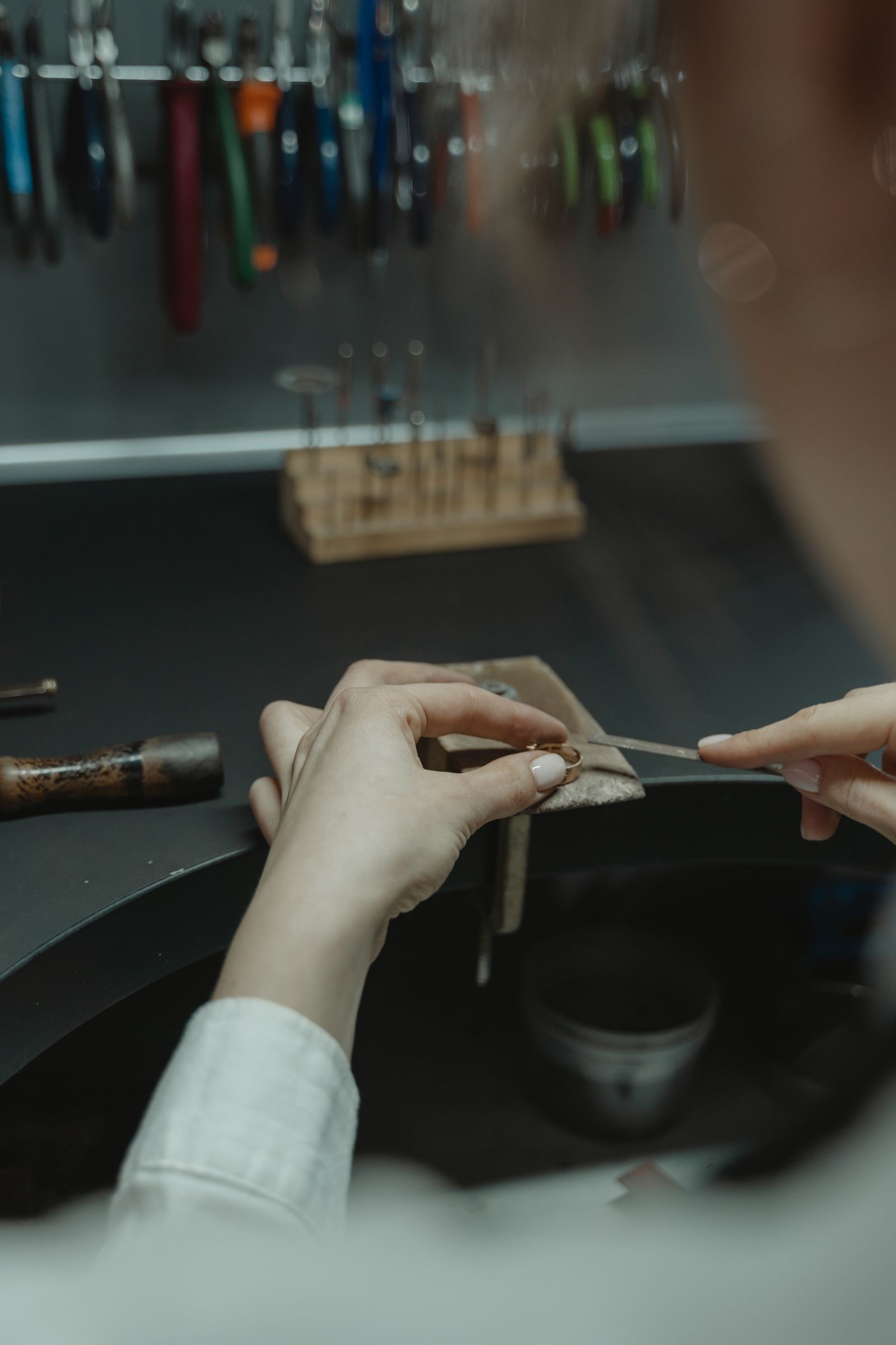 Mains d'un artisan bijoutier à l'établi
