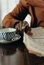 Person Holding White and Blue Floral Ceramic Teacup