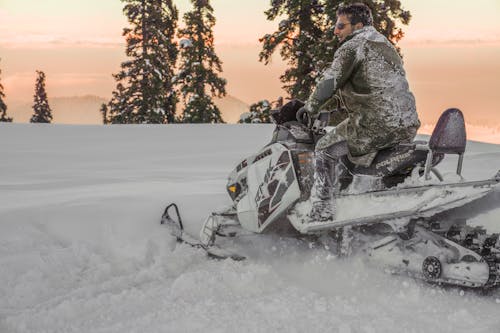 Person Wearing Sunglasses Riding Snow Mobile