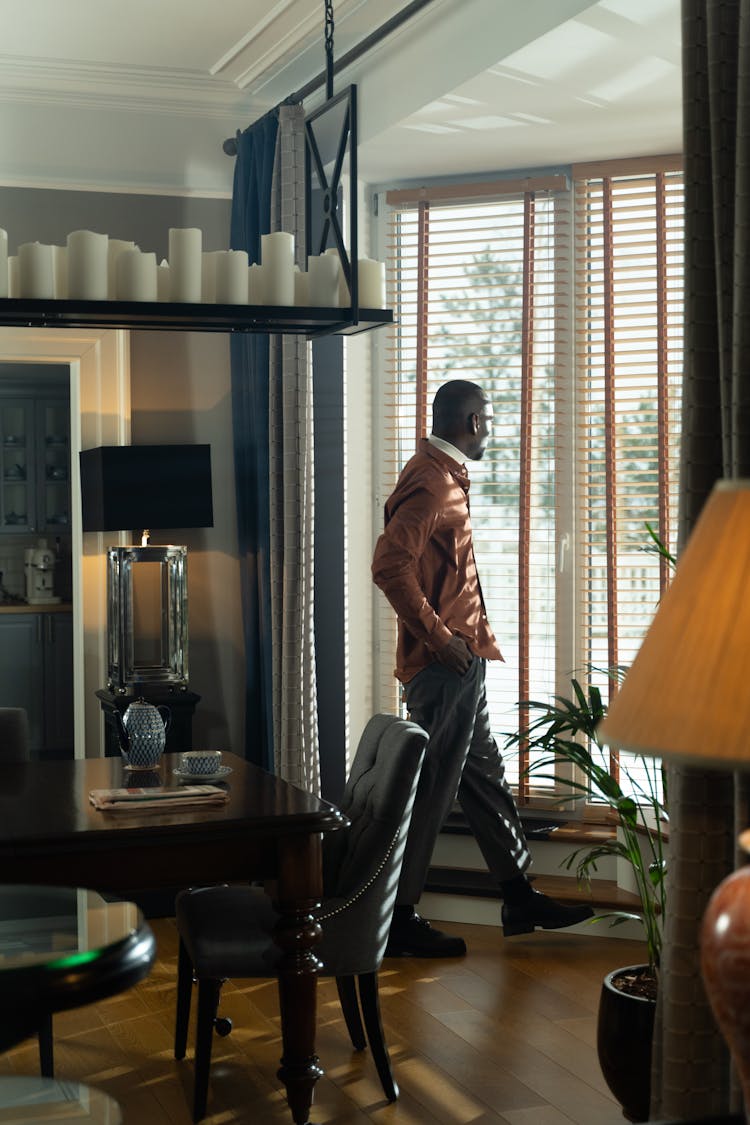 Man Near The Window With Wooden Blinds