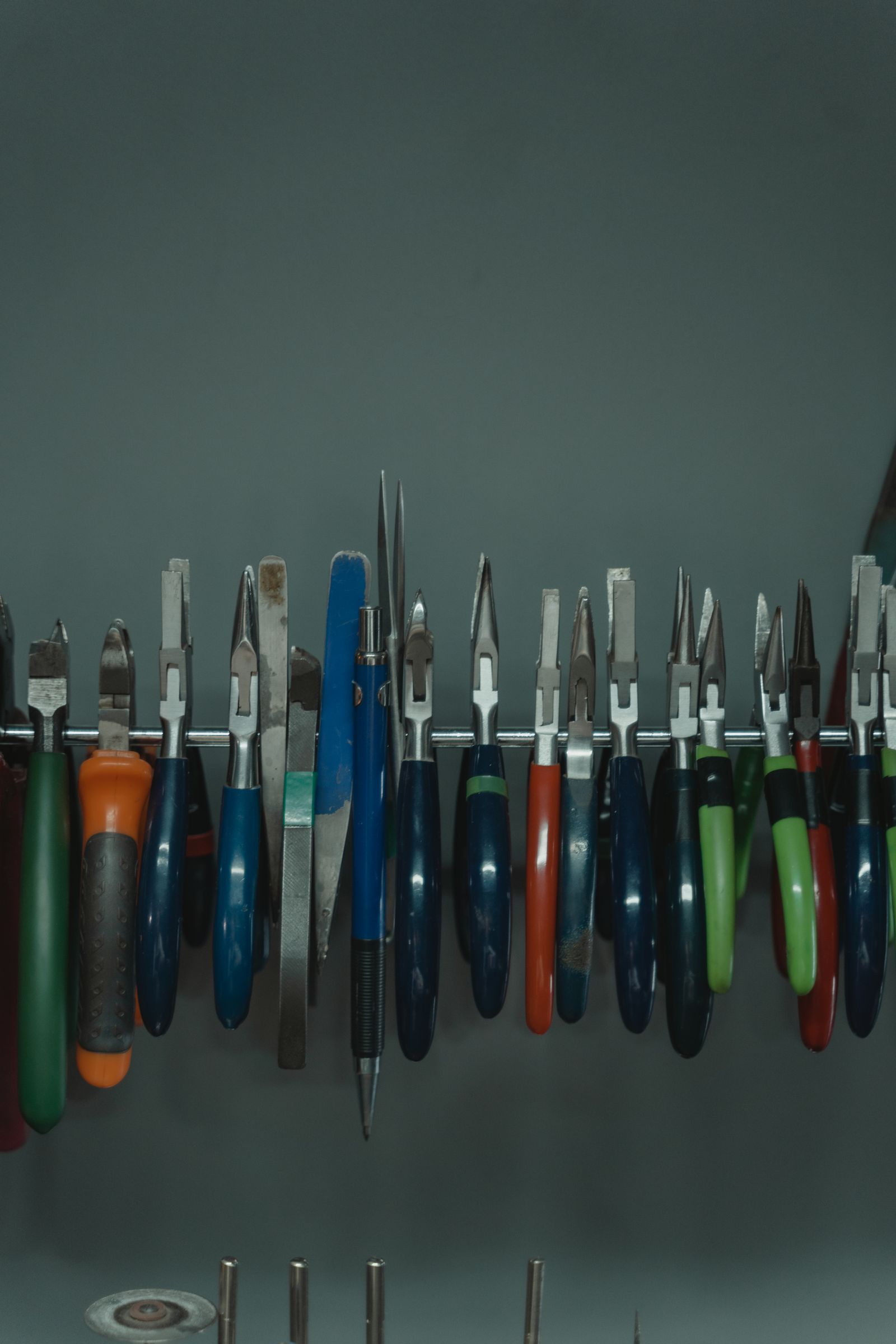 Outils d'électricien accrochés sur tige métallique en atelier, rangement rigoureux