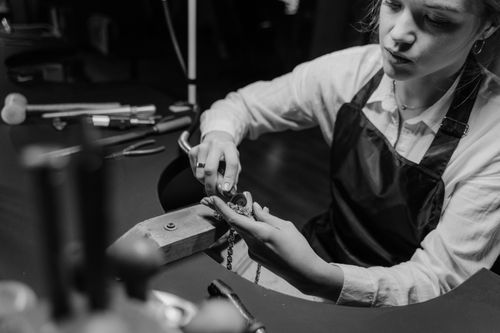 Free A jeweler meticulously working on a necklace with precision tools in a workshop setting. Stock Photo