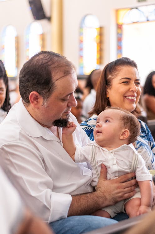 Free Happy parents with cute baby sitting in church Stock Photo