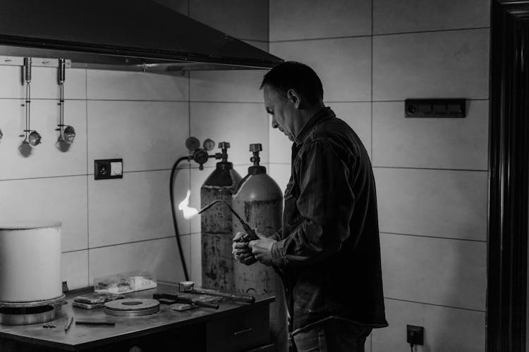 Man In Long Sleeve Shirt Using A Soldering Torch