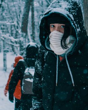 A group of hikers bundled up for a winter trek through a snowy forest, showcasing adventure and exploration.