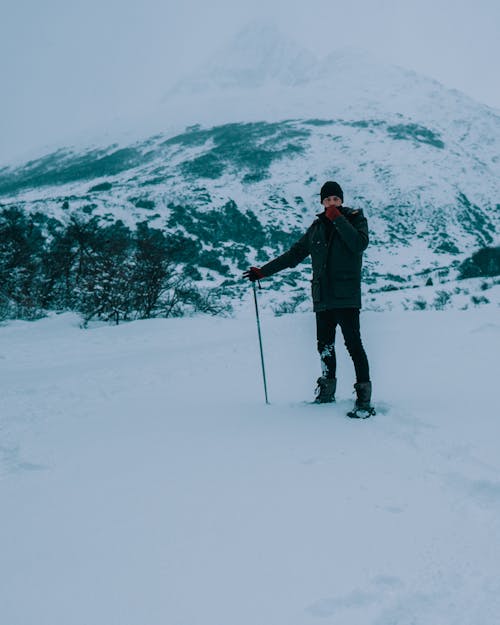 Hombre De Chaqueta Negra Y Pantalón Negro De Pie Sobre Un Suelo Cubierto De Nieve