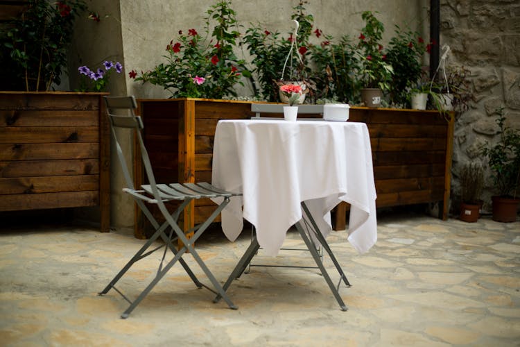 A Seat And A Table With White Table Cloth