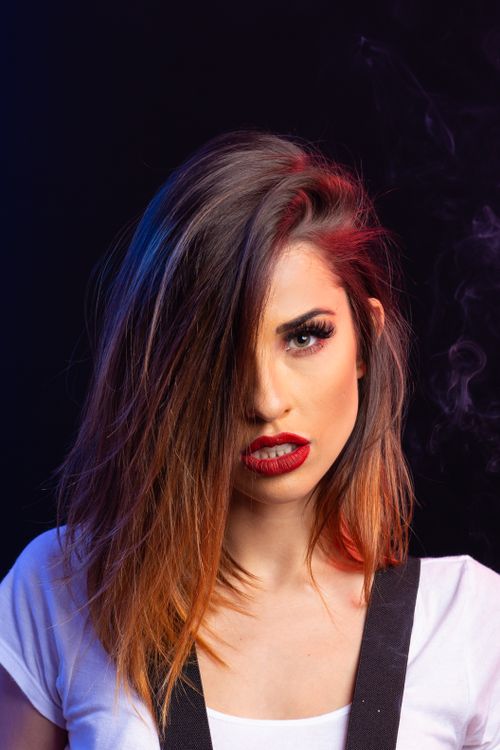 Free Striking portrait of a woman with bold makeup and vibrant hair color, exuding confidence. Stock Photo
