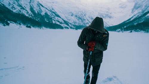 Uomo In Giacca Nera E Pantaloni Neri In Piedi Su Un Terreno Innevato