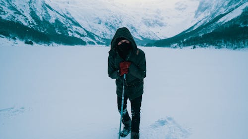 Homem De Jaqueta Preta E Calça Preta Em Pé No Solo Coberto De Neve
