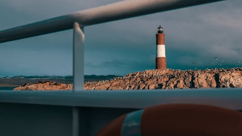 Black and White Lighthouse on Brown Sand