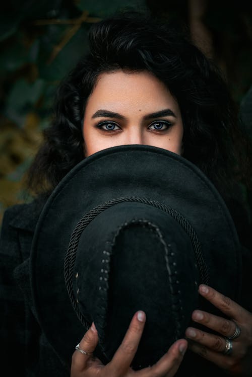 Woman Covering Her Face with Black Hat