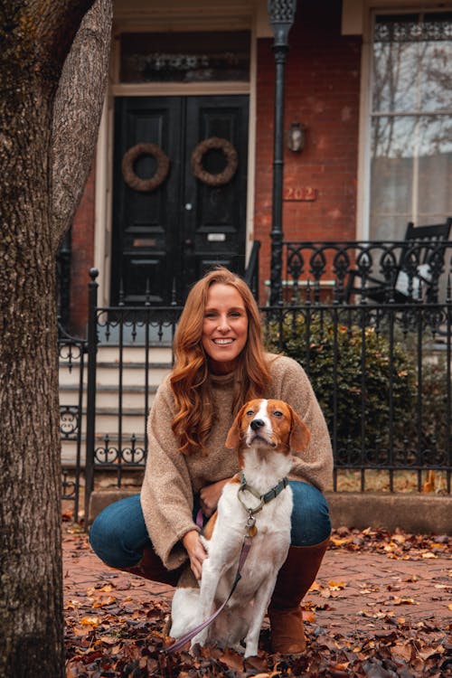 Woman in Brown Sweater Sitting with a Dog