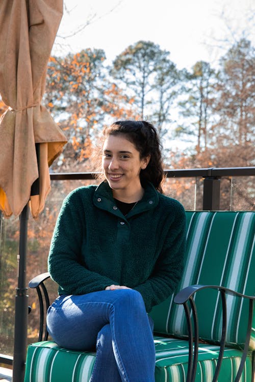 Woman Sitting on a Terrace and Smiling 