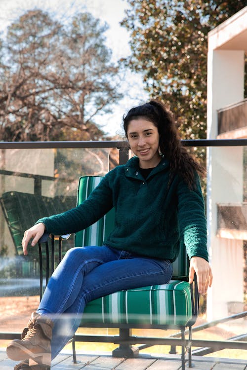 Woman in Sweater Sitting on a Green Chair
