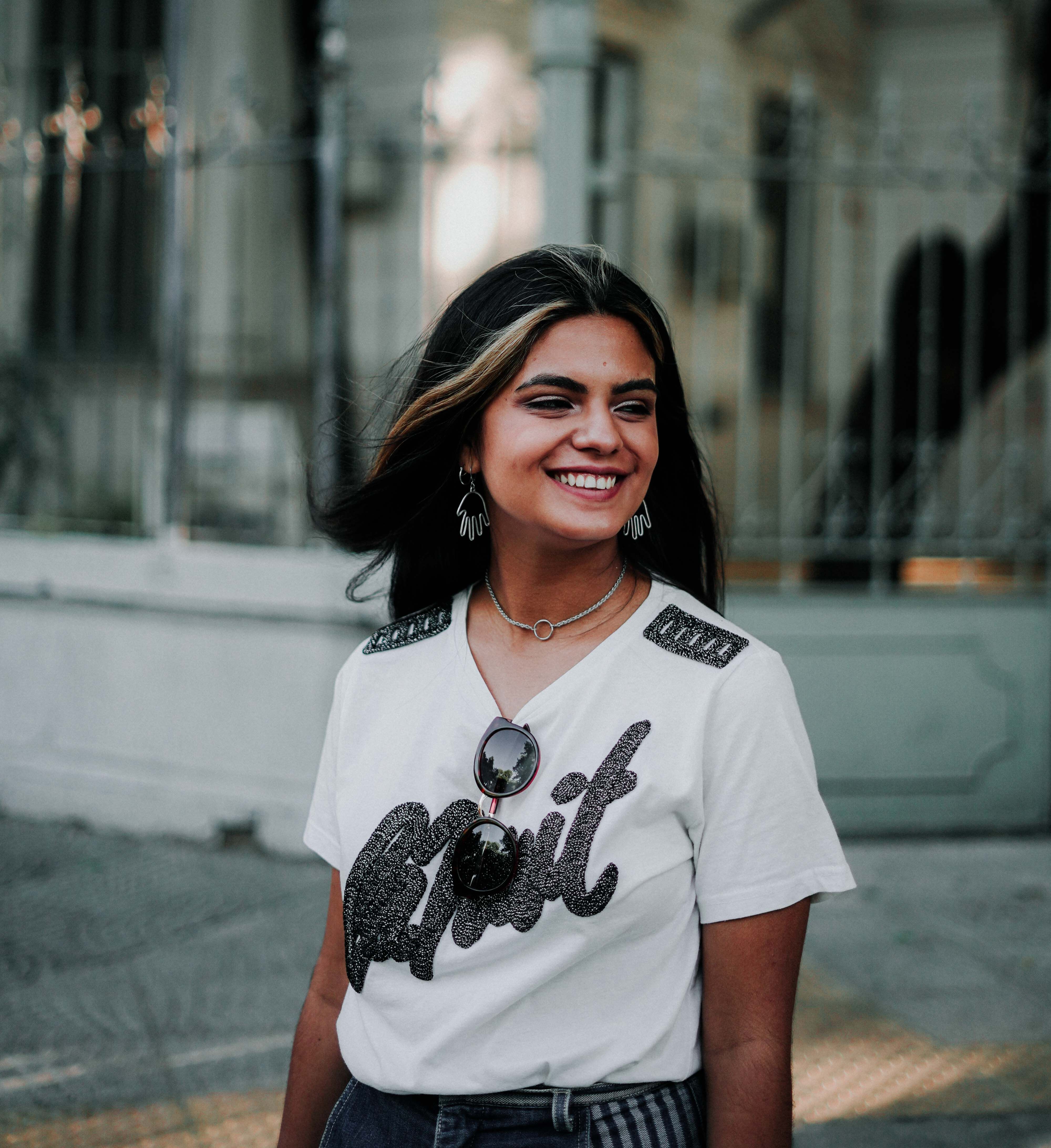 Young woman smiling in a trendy white shirt on the streets of Buenos Aires.