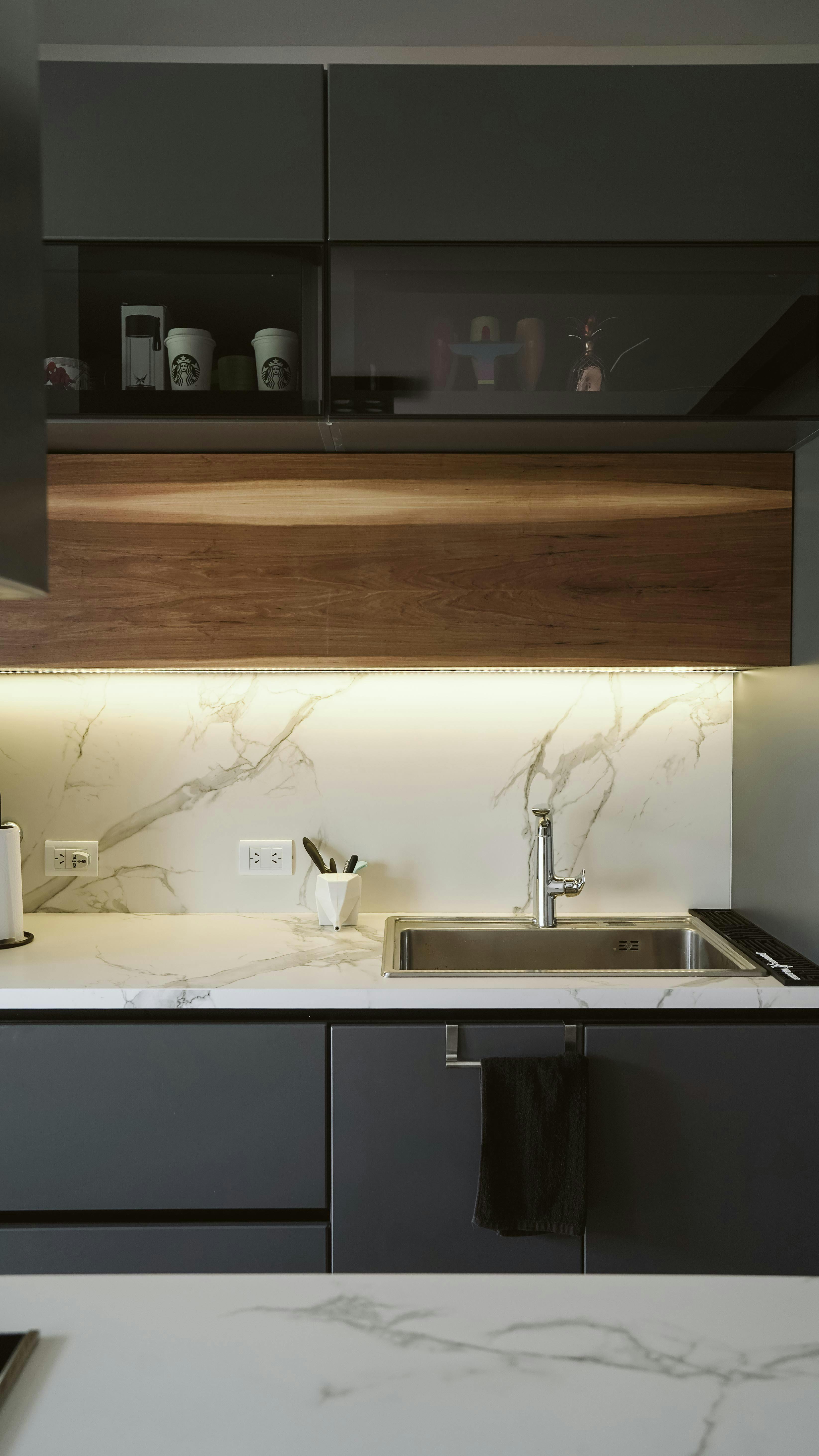 Sleek kitchen with marble countertops, stainless steel sink, and LED lighting for a modern touch.