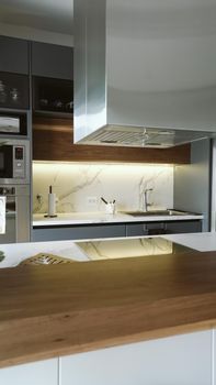 Sleek minimalist kitchen featuring marble backsplash and stainless steel appliances for a contemporary look.