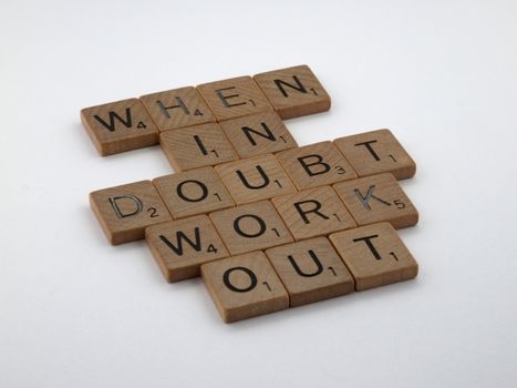 Scrabble tiles arranged to spell a motivational quote on a white background.