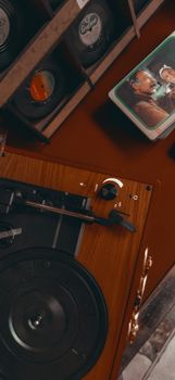 Top view of a vintage turntable with vinyl records and old photographs, evoking nostalgia.
