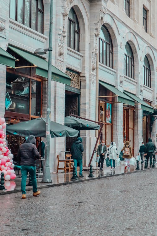 People Walking in Rain on City Street