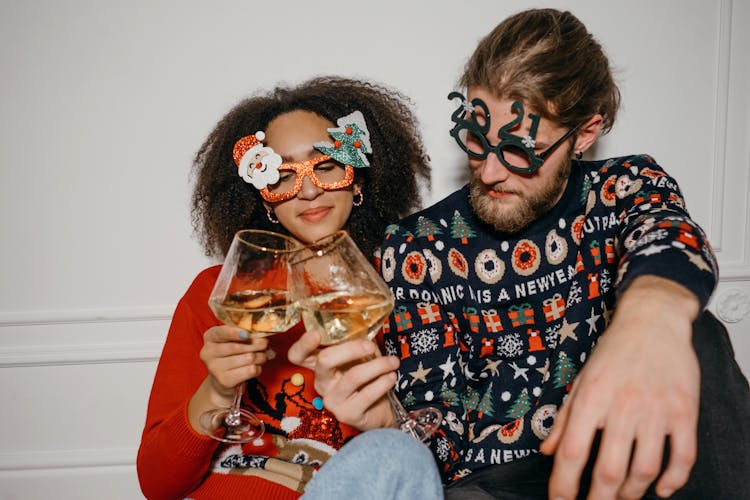 A Couple Toasting Their Glasses Of Wine