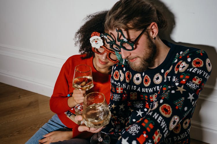 A Couple Holding Glasses Of Wine