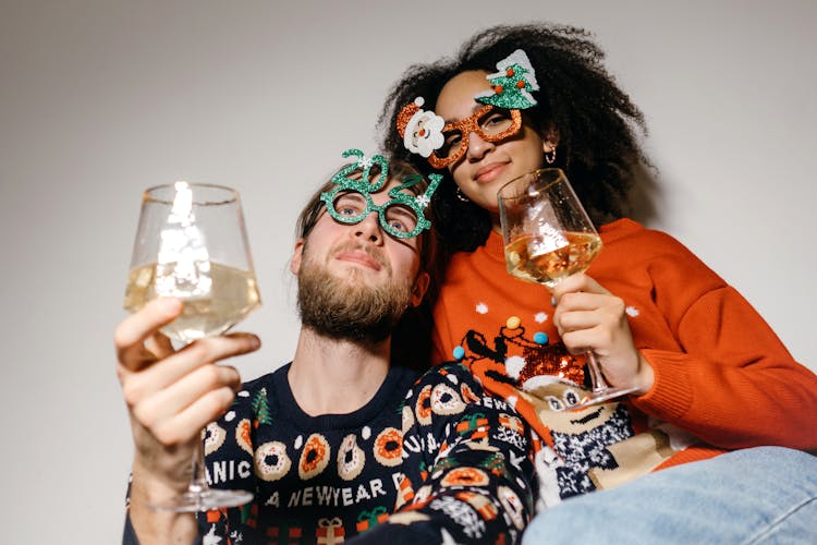 A Couple Holding Glasses Of Wine