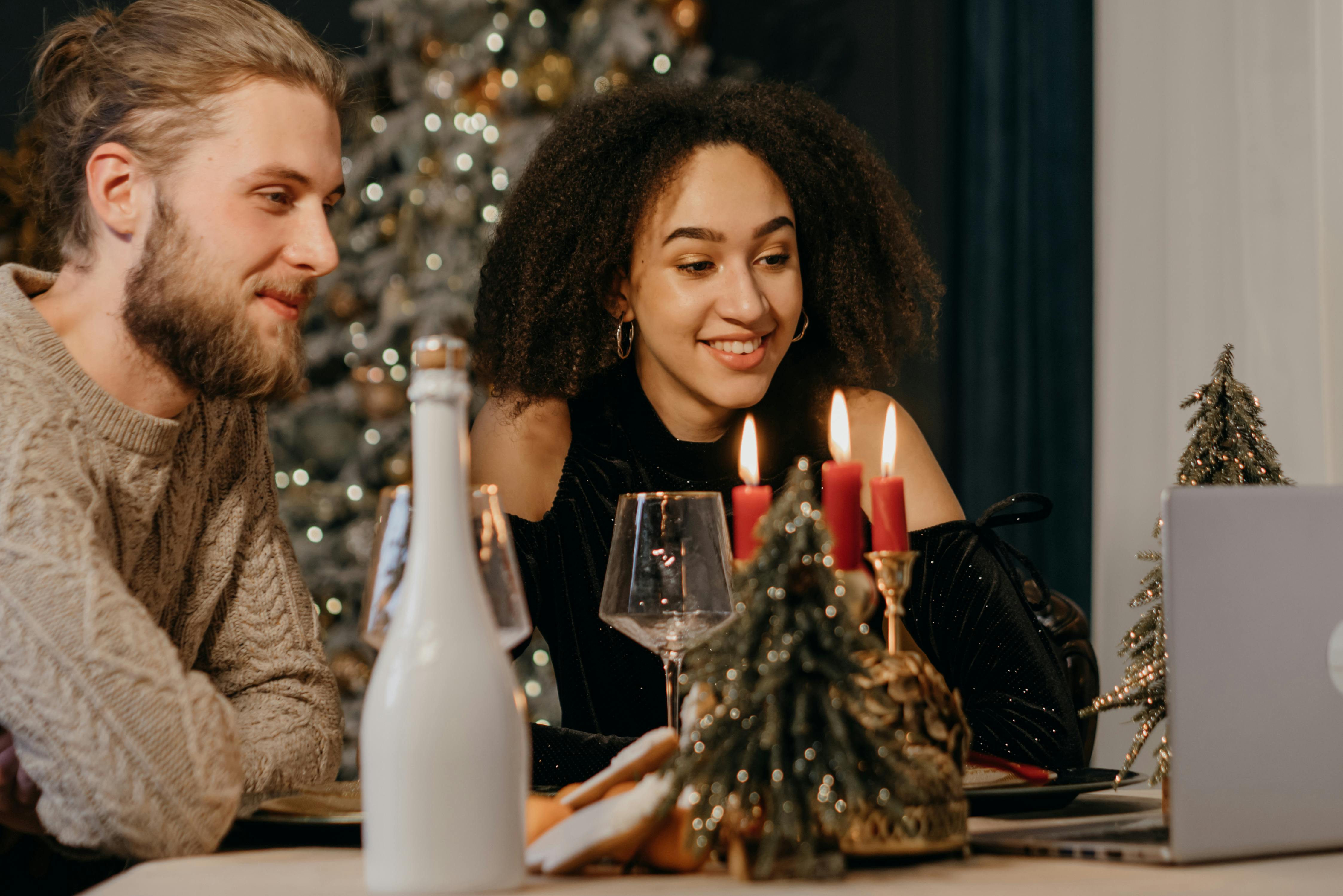 couple sitting on table while talking on online video call