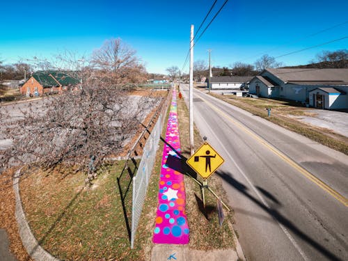 Free Road along multicolored graffiti and suburb houses Stock Photo