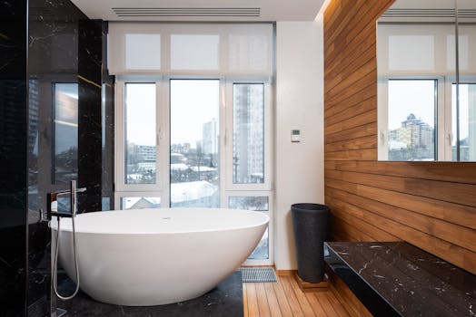 Sleek bathroom featuring a contemporary bathtub and city skyline view.