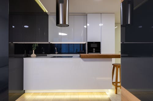 Interior of stylish kitchen with counter and appliances with cabinets glossy reflecting surface