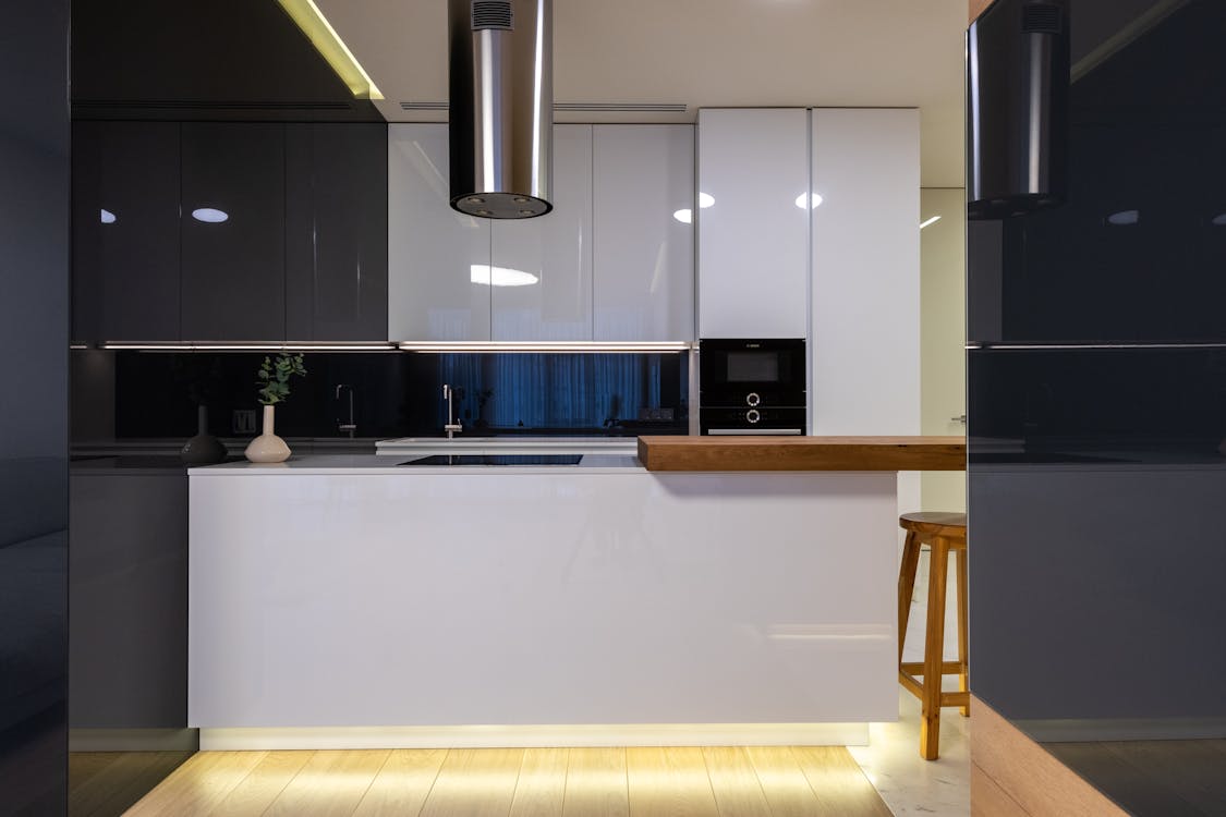 Interior of stylish kitchen with counter and appliances with cabinets glossy reflecting surface