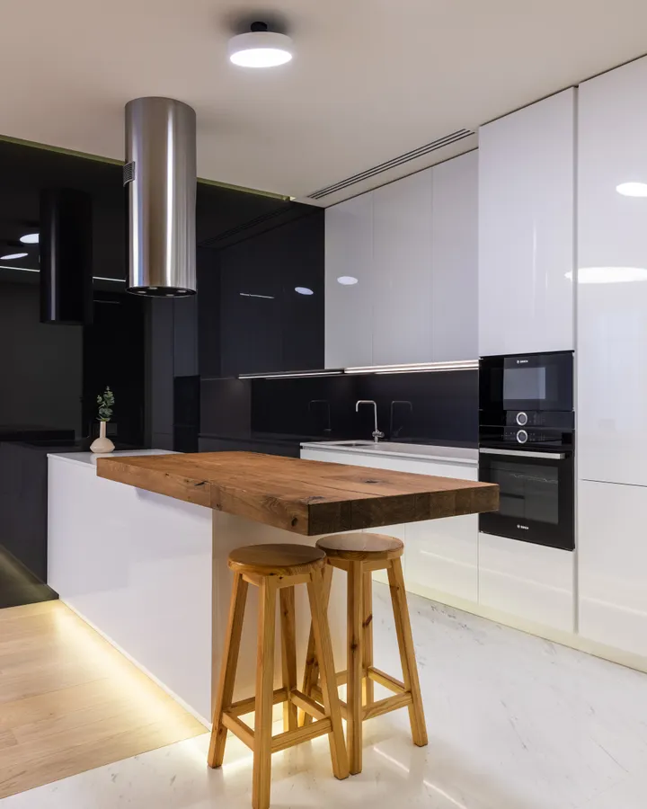 Contact our refrigerator repair team Kitchen with glossy cabinets in an apartment with a living area