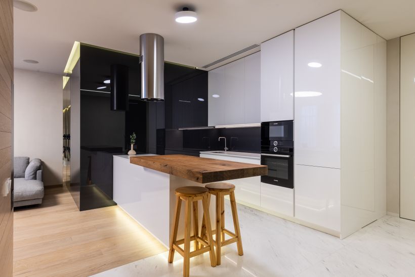 Open kitchen with a timber breakfast bar in a two-bedroom unit — photo by Max Vakhtbovych on Pexels