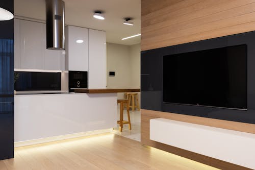 黑色的純平電視，在白色的木製電視機架上