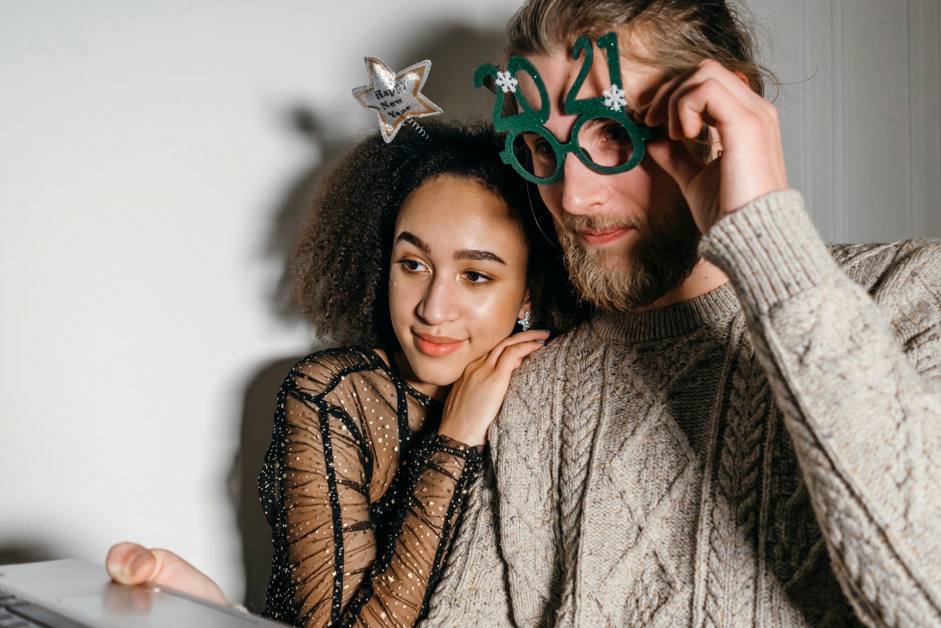 Couple enjoying New Year celebration with a virtual gathering at home.