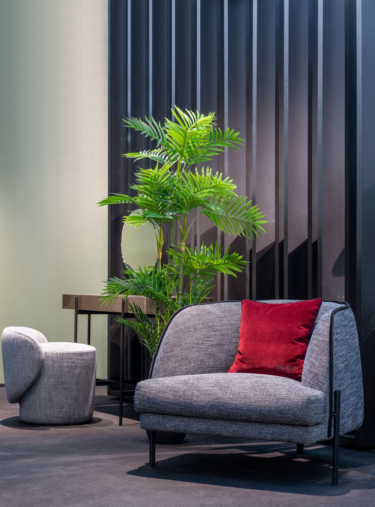 Gray upholstered ottoman beside an armchair in a modern living room.