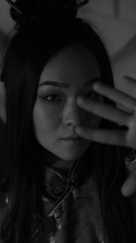 Black and white close-up portrait of a young woman gazing at the camera with expressive eyes.